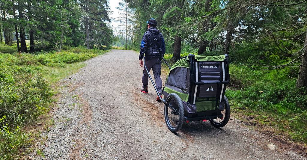 Child hiking trailer in nature. Green. Nordic Cab