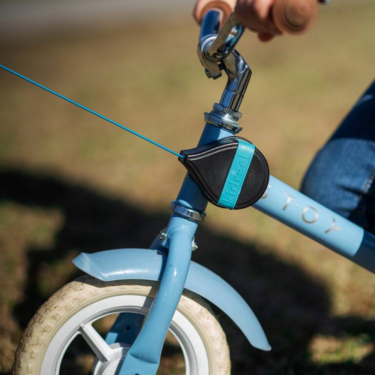 kidreel in action on blue bike