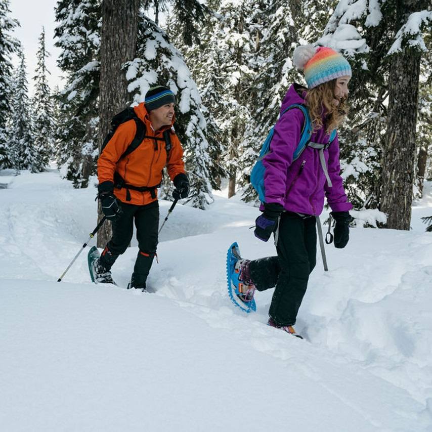 girl walking in the snow with snowshes | Crescent Moon